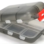 Mini pastillero transparente con compartimentos y cierre rojo.