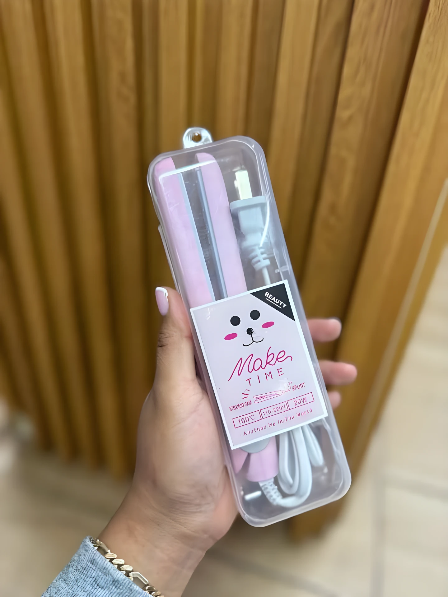 Mini plancha alisadora portátil rosa en estuche transparente. Ideal para retocar peinados.