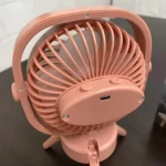 Mini ventilador de escritorio plegable rosa recargable con luz LED, vista trasera.