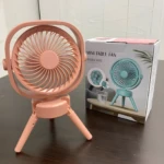 Mini ventilador rosa de escritorio plegable, diseño moderno con base tipo trípode, ideal para refrescar espacios.