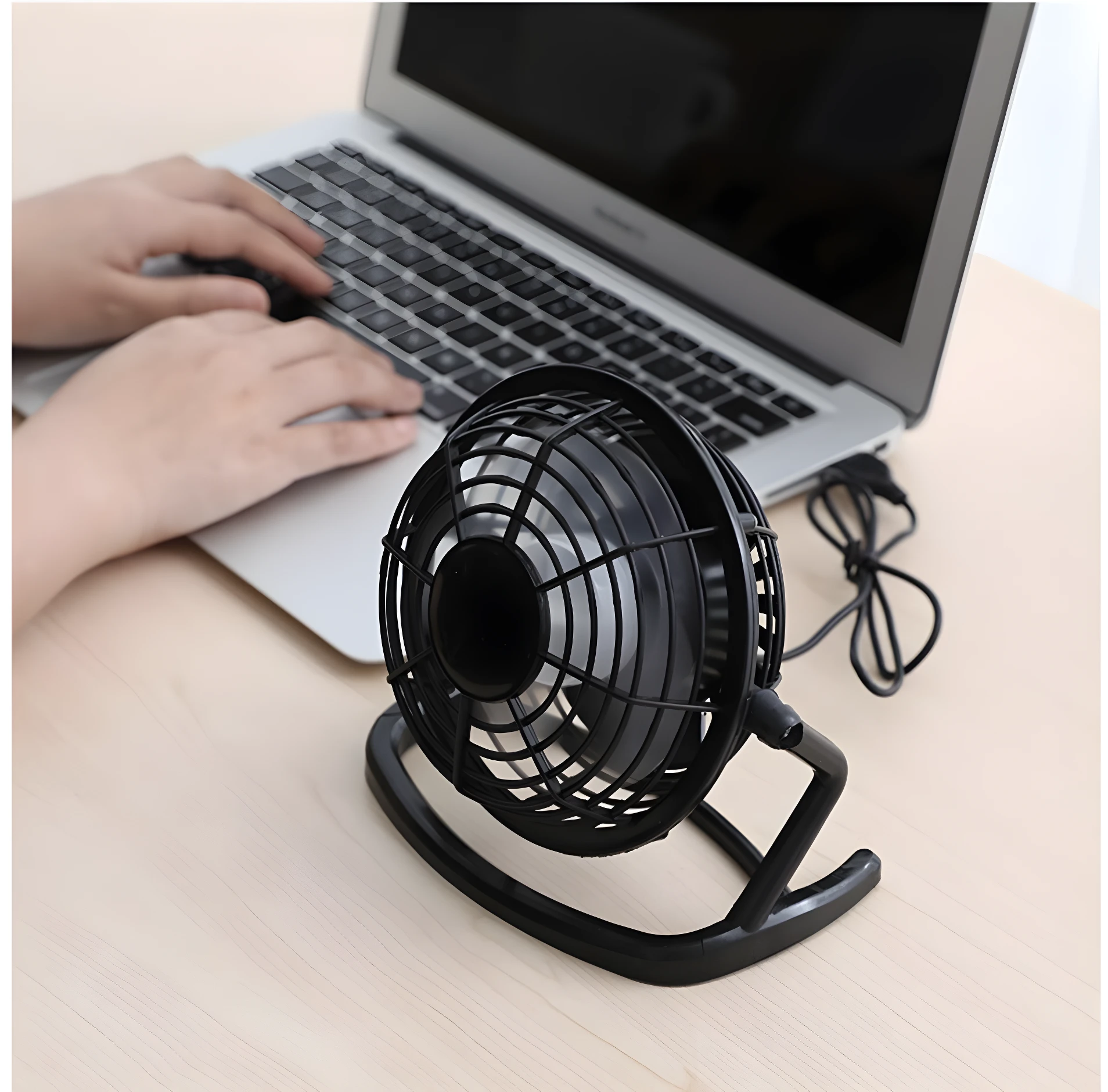 Mini ventilador USB negro para escritorio, conectado a portátil, para enfriar tu espacio de trabajo.