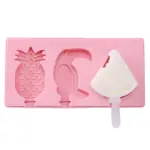 Molde rosa de silicona para helados con figuras de piña, tucán y un molde ocupado con paleta blanca de sandía mordida.