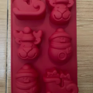 Molde de silicona rojo para repostería navideña con 6 cavidades: reno, muñeco de nieve y trineo.