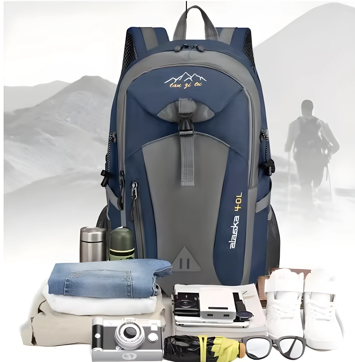 Morral de viaje azul y gris para senderismo, con ropa apilada, cámara y zapatos deportivos.