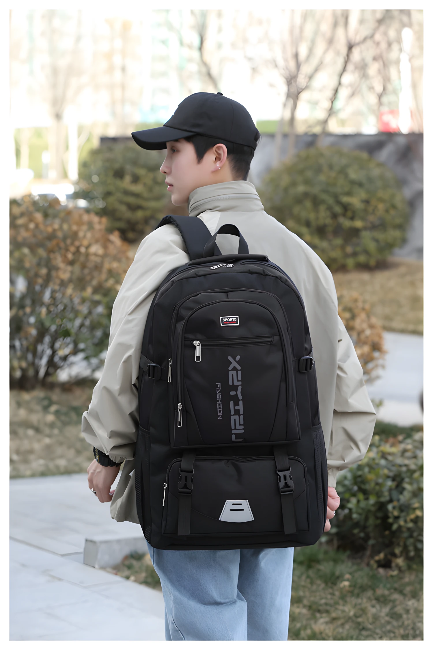 Mochilero negro para hombre, con logo plateado y correas ajustables, visto desde atrás.