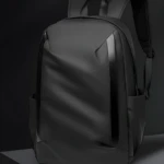 Morral negro minimalista Hh01, diseño moderno y funcional, sobre base gris.