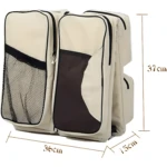 Morral pañalera convertible beige con compartimentos de malla y cuna de viaje incorporada.