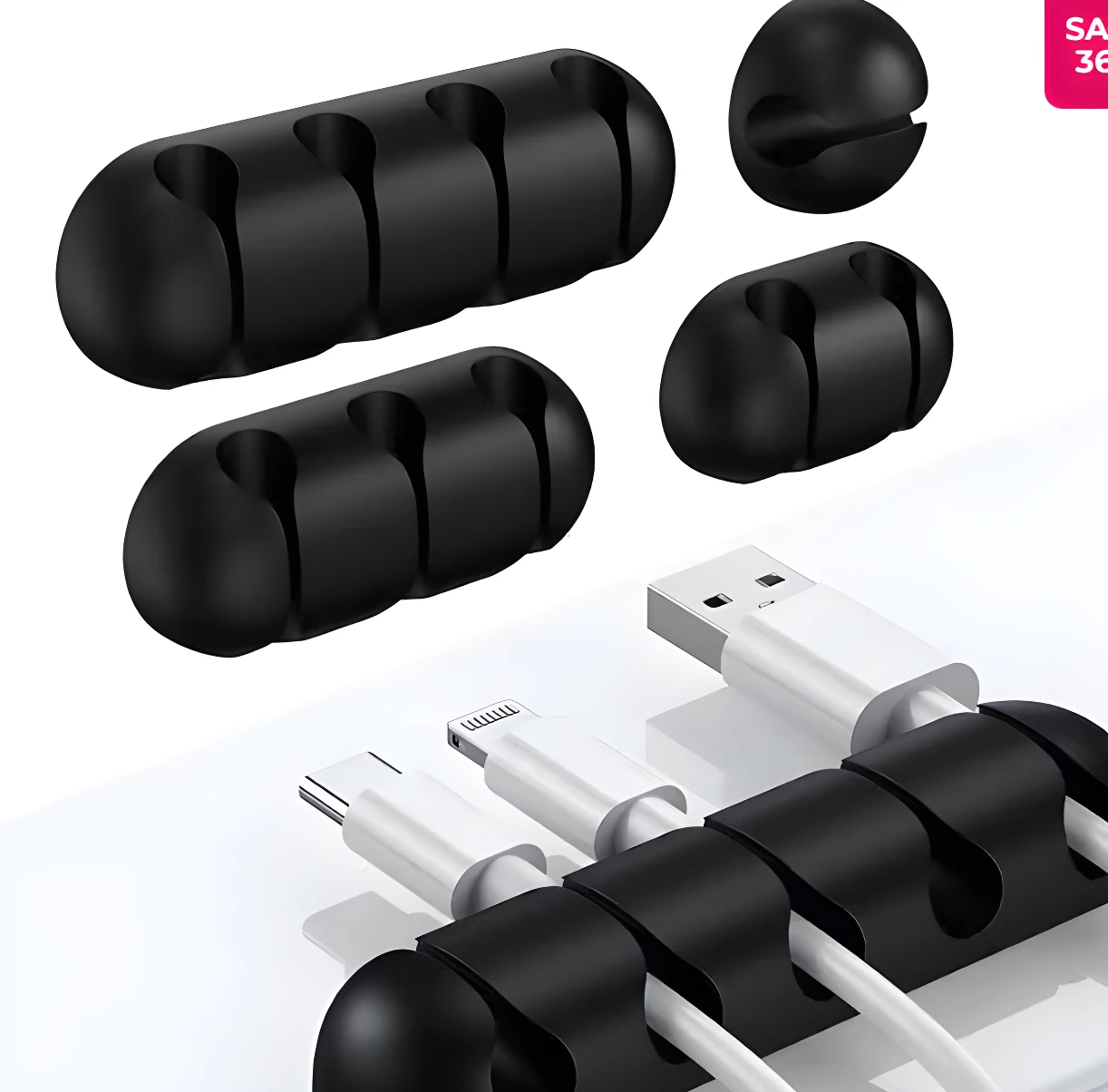 Organizadores adhesivos negros de silicona para cables. Se ven dos piezas de 4 ranuras y piezas sueltas, sujetando cables USB en un escritorio blanco.