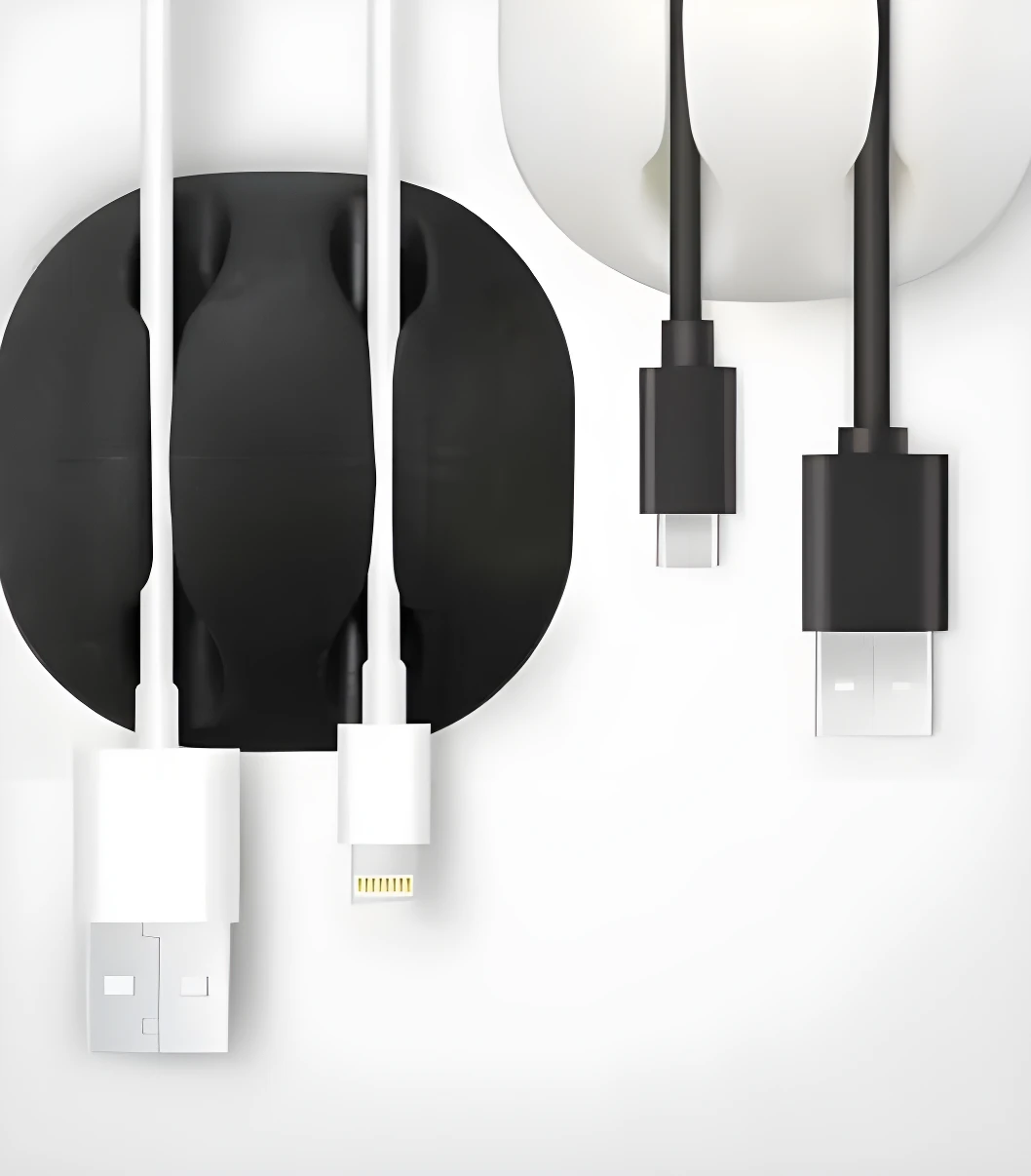 Organizador de cables negro y blanco sosteniendo cables USB-A, Lightning y USB-C en escritorio minimalista.