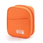Organizador de cables naranja vibrante con cierre rojo, bolsillo frontal y tres iconos blancos de accesorios electrónicos.
