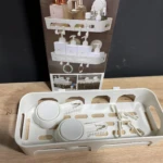 Estante organizador blanco de ducha con soportes y clips para accesorios de baño.