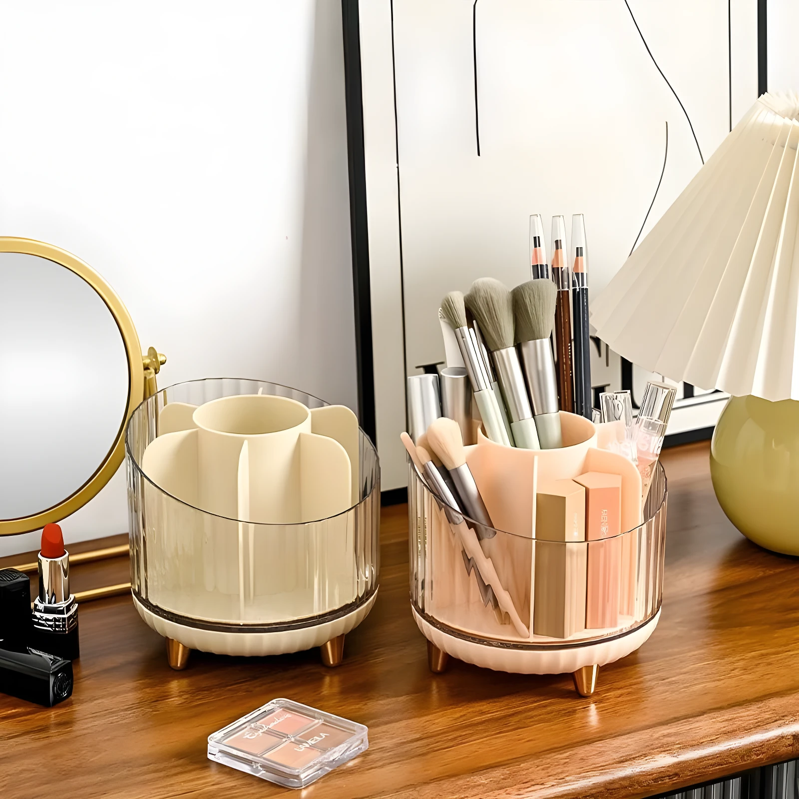 Dos organizadores redondos de acrílico y plástico, uno beige y otro rosado, exhibiendo brochas de maquillaje, lápices y labiales sobre una cómoda de madera.