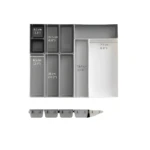 Organizador de cubiertos gris modular con compartimentos y medidas visibles.