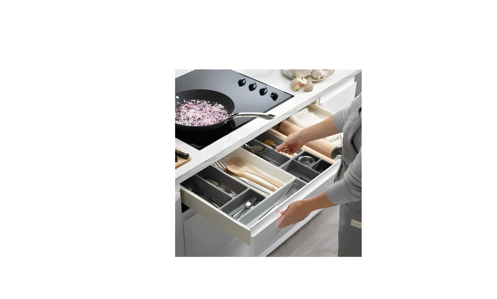 Organizador de cubiertos gris y blanco en cajón de cocina con utensilios y rodillo para amasar.