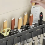 Organizador de cocina negro con cuchillos de madera, tijeras y utensilios colgando.