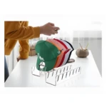 Organizador acrílico transparente para 7 gorras, ideal para exhibir y conservar su forma.
