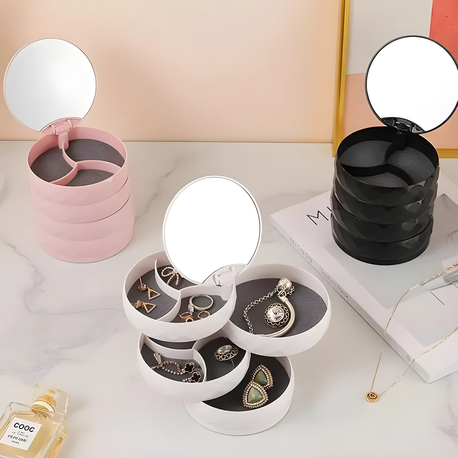 Organizador de joyas compacto apilable con espejo, disponible en rosa y negro, ideal para guardar accesorios.