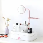 Organizador de maquillaje blanco con espejo rosa, cajón y compartimentos para cosméticos.