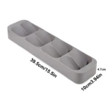 Bandeja organizadora gris para cubiertos o especias, con 5 compartimentos inclinados. Mide 39.5cm de largo por 10cm de ancho y 4.7cm de alto.