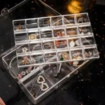 Organizador acrílico transparente apilable con 24 compartimentos para joyería, ideal para clasificar aretes, anillos y pulseras.