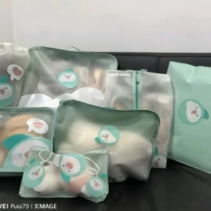 Set de 7 organizadores viajeros para niños con diseño de pingüino, en tonos menta, ideales para clasificar ropa y juguetes en maletas.