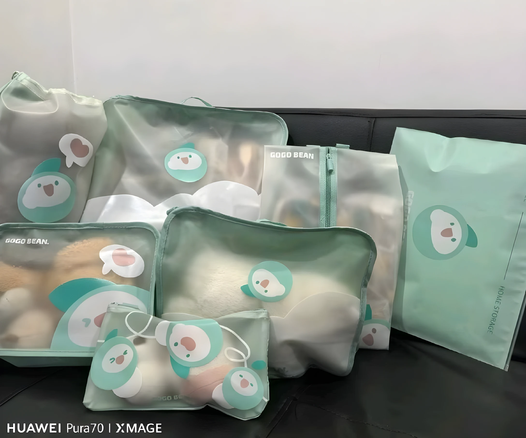 Set de 7 organizadores viajeros para niños con diseño de pingüino, en tonos menta, ideales para clasificar ropa y juguetes en maletas.