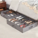 Organizador gris para zapatos bajo cama, con compartimentos y tapa transparente, ideal para dormitorio.