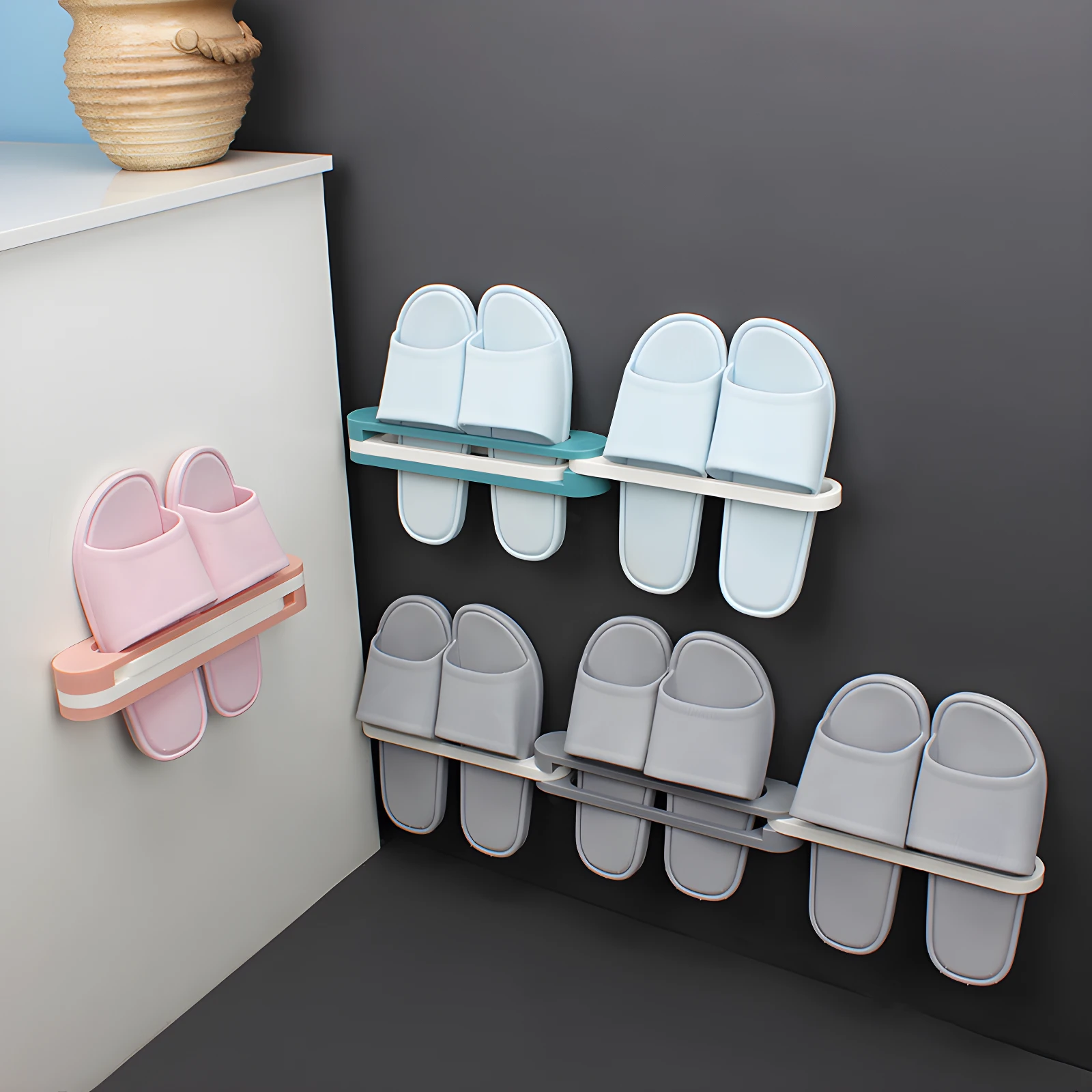 Soportes adhesivos para colgar hasta 6 pares de pantuflas, colores azul claro, gris y rosa, organizando calzado en pared blanca y oscura.
