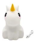 Parlante unicornio blanco suave con luz LED, cuerno amarillo, ojos negros y rosados, cable USB incluido.