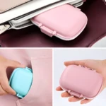 Pastillero con cortador rosa y azul, compacto y portátil, ideal para llevar pastillas.