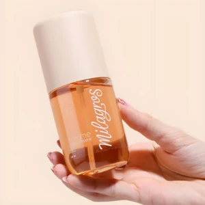 Perfume capilar y corporal Bali Milagros con tapa beige, líquido ámbar, en mano, refresca piel y cabello.