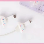 Set x2 protectores de cable kawaii para cargadores iPhone, color blanco con carita de personaje.