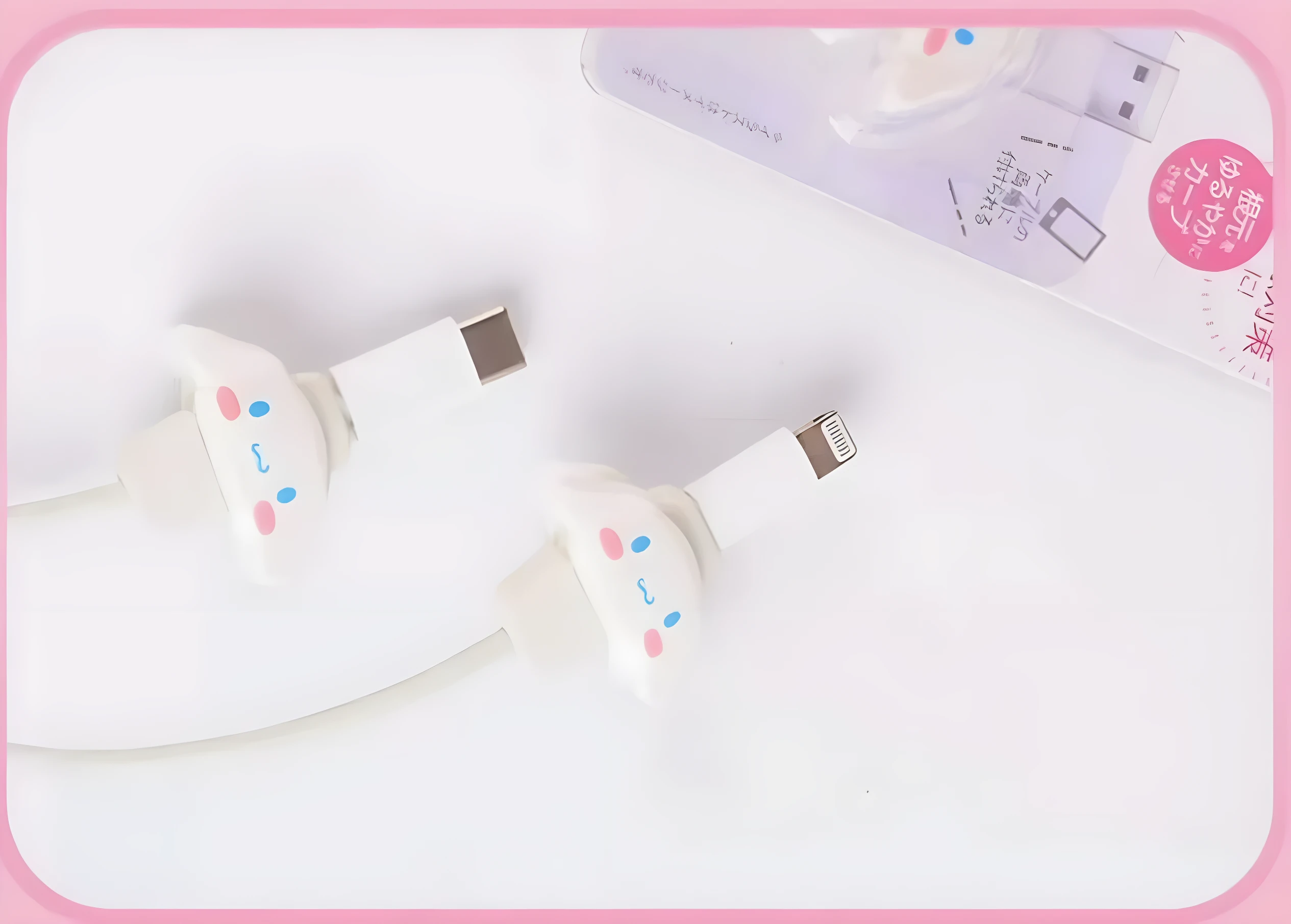 Set x2 protectores de cable kawaii para cargadores iPhone, color blanco con carita de personaje.