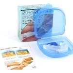 Antirronquidos bucal de silicona transparente en estuche azul, junto a su caja y folleto de principio de funcionamiento.