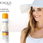 Protector solar en spray BIOAQUA Rice Raw Pulp SPF 50, con mujer sonriente y sombrero blanco.