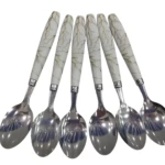 Seis cucharas con mango blanco veteado estilo mármol y líneas doradas, cabezas de metal plateado brillante.