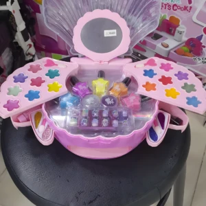 Set de maquillaje infantil en estuche concha rosa, con espejito, sombras, labiales y uñas postizas.