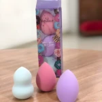 Set de 3 esponjas de maquillaje RubyFace en forma de huevo, colores pastel, sobre mesa de madera.