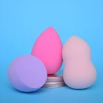 Set de tres pomos de maquillaje, lavanda, rosa fuerte y rosa pálido, sobre tapa metálica.