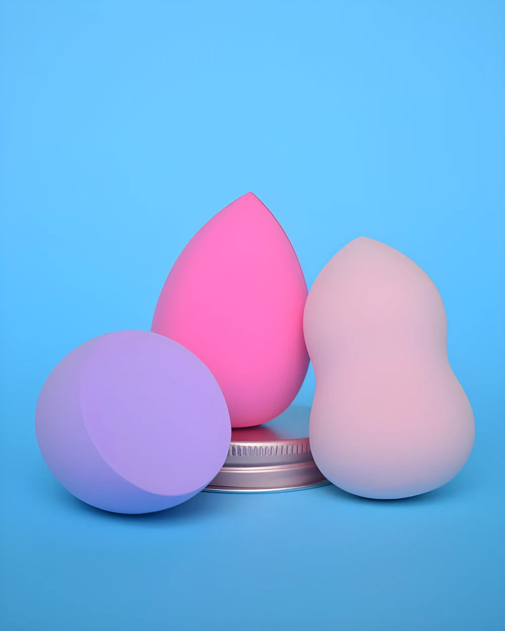 Set de tres pomos de maquillaje, lavanda, rosa fuerte y rosa pálido, sobre tapa metálica.