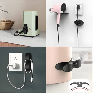 Dos soportes negros duales para cables, uno sujetando un secador rosa y otro un cable USB, más ejemplos de uso en pared y electrodomésticos.