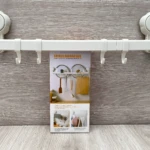 Organizador blanco con ganchos colgantes y ventosas para cocina, ideal para colgar utensilios.