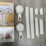Organizador de cocina blanco con ventosas y ganchos para colgar, ideal para utensilios y tapas.