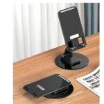 Set x4 soportes plegables negros para celular, ajustables en ángulo, sobre escritorio de madera.