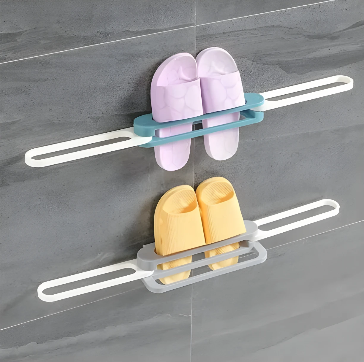 Dos soportes de pared grises y turquesas con sandalias puestas, uno con chanclas lilas y otro con amarillas.