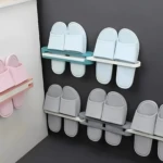 Soportes adhesivos para sandalias, uno rosa y dos con sandalias celestes y grises, para organización en baño.