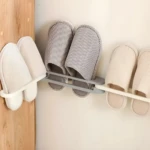 Soporte adhesivo gris para 4 pares de sandalias con franjas blancas y grises.
