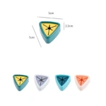 Soporte triangular adhesivo para paños de cocina/baño. Muestra cuatro colores: verde azulado, lila, turquesa y salmón. Dimensiones 5cm x 2.2cm.