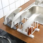 Dos escurridores de platos y tapas: uno gris con tres platos y otro blanco con un cucharón de madera junto a platos.