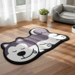 Tapete para mascotas con diseño de perro husky durmiendo en tonos morado y blanco, sobre piso de madera iluminado por luz natural.